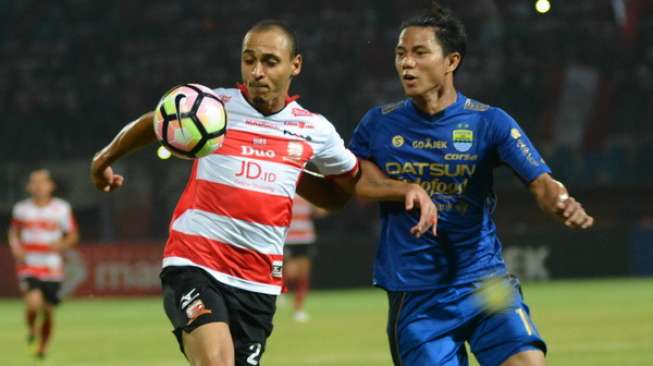 Striker Madura United, Peter Osase Odemwingie (kiri) berusaha melewati pemain Persib Bandung, Ahmad Jufrianto, saat pertandingan Liga 1 di Stadion Gelora Ratu Pamelingan (SGRP) Pamekasan, Jatim, Minggu (9/7). [Antara]