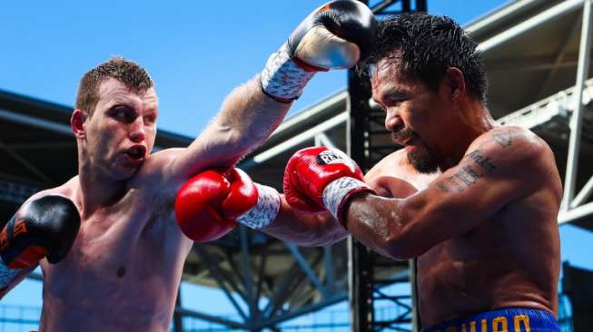 Petinju Australia, Jeff Horn, mendaratkan straight kiri ke kepala Manny Pacquiao dalam duel perebutan juara dunia tinju kelas welter WBO di Suncorp Stadium, Brisbane, Australia, (2/7). [AFP/Patrick Hamilton]