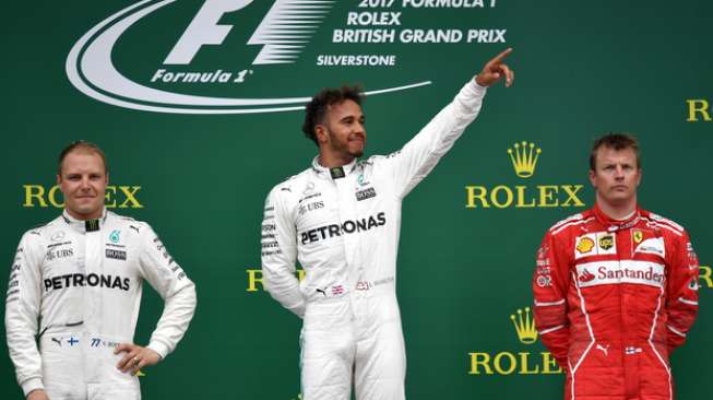 Pebalap Mercedes, Lewis Hamilton (tengah), menjuarai seri 10 F1 GP Inggris disusul kemudian oleh rekan setimnya, Valtteri Bottas (kiri), dan pebalap Ferrari, Kimi Raikkonen, di Sirkuit Silverstone, Minggu (16/7/2017). [AFP/Andrej Isakovic]