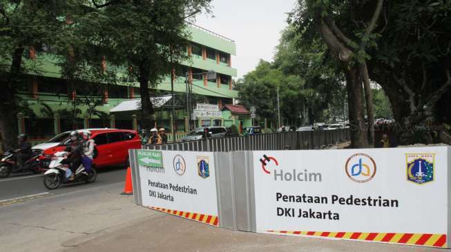 Pekerja menyelesaikan pembangunan pedestrian di Jalan Perwira, Jakarta, Selasa (18/7).