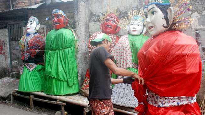 Perajin menyelesaikan pembuatan Ondel-ondel boneka khas Betawi di Kramat Pulo, Jakarta, Selasa (18/7). 