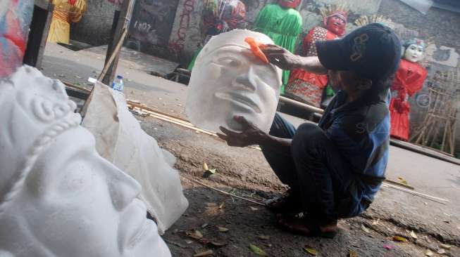 Perajin menyelesaikan pembuatan Ondel-ondel boneka khas Betawi di Kramat Pulo, Jakarta, Selasa (18/7). 