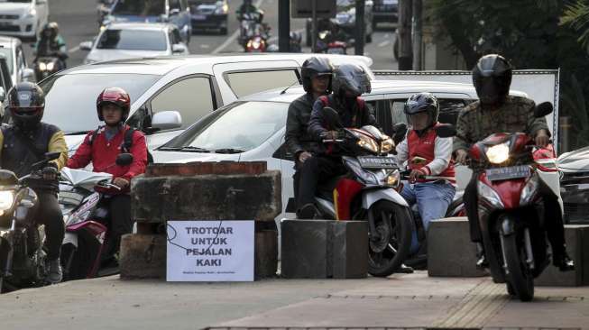 Koalisi Pejalan Kaki melakukan aksi menghadang pengendara sepeda motor yang melintas di trotoar di kawasan Casablanca, Jakarta, Jumat (21/7).