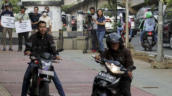 Koalisi Pejalan Kaki melakukan aksi menghadang pengendara sepeda motor yang melintas di trotoar di kawasan Casablanca, Jakarta, Jumat (21/7).