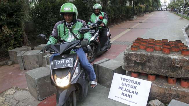 Koalisi Pejalan Kaki melakukan aksi menghadang pengendara sepeda motor yang melintas di trotoar di kawasan Casablanca, Jakarta, Jumat (21/7).