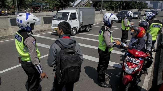 Suasana penindakan oleh polisi kepada pengendara sepeda motor yang melanggar larangan melintas di jalan layang non tol Casablanca, Jakarta Selatan, Rabu (26/7/2017). [Suara.com/Kurniawan Mas'ud]