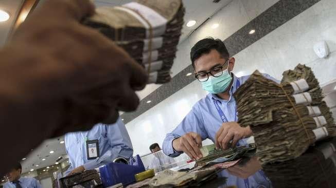 Warga menukarkan uang Rupiah yang tidak layak edar dari berbagai pecahan di loket Gedung C Bank Indonesia, Jakarta, Rabu (26/7/2017). [Suara.com/Kurniawan Mas'ud]