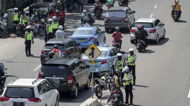 Suasana saat polisi melakukan penindakan kepada pengendara sepeda motor yang melanggar larangan melintas di jalan layang non tol Casablanca, Jakarta Selatan, Rabu (26/7/2017). [Suara.com/Kurniawan Mas'ud]