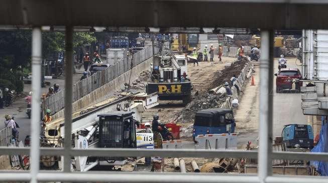 Sejumlah kendaraan melintas di samping proyek pembangunan 