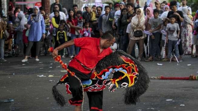 Pengunjung wisata Taman Mini Indonesia Indah (TMII) di Jakarta, Minggu (30/7).