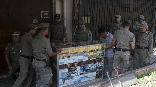 Petugas Satpol PP melakukan penertiban pedagang kaki lima yang berjualan di trotoar jalan kawasan Jatinegara, Jakarta, Rabu (2/8).