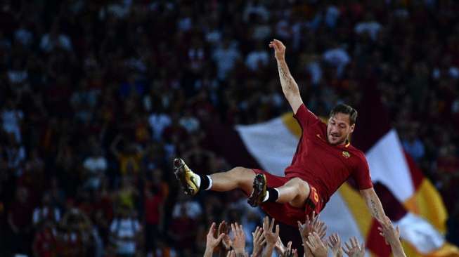 Kapten AS Roma, Francesco Totti, dibopong rekan-rekan setimnya usai menjalani laga terakhirnya di Serie A pada 28 Mei 2017. Totti pensiun pada usia 40 tahun. [AFP/Vincezo Pinto]