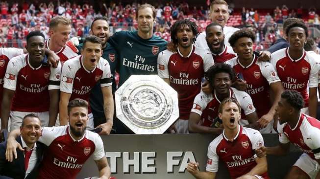 Para pemain Arsenal berpose dengan trofi Community Shield setelah mengalahkan Chelsea dalam adu penalti di Wembley Stadium. Ian KINGTON / AFP