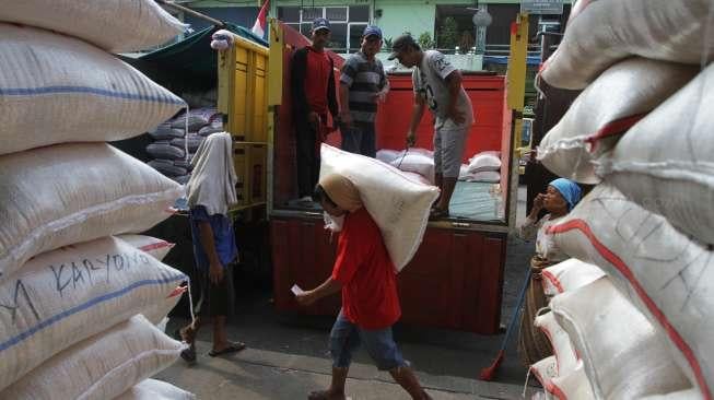 Pekerja tampak mengangkat beras jenis medium di Pasar Induk Beras Cipinang, Jakarta, Senin (7/8/2017). [Suara.com/Kurniawan Mas'ud]