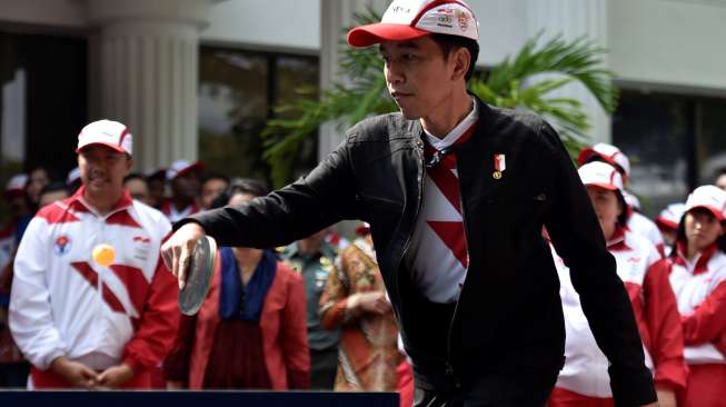 Presiden Joko Widodo ketika bermain tenis meja melawan Susy Susanti dan atlet senior tenis meja Jopie Warsono, usai melepas kontingen Indonesia ke SEA Games XXIX Malaysia di Kompleks Istana Kepresidenan, Jakarta, Senin (7/8/2017). [Antara/Puspa Perwitasari]