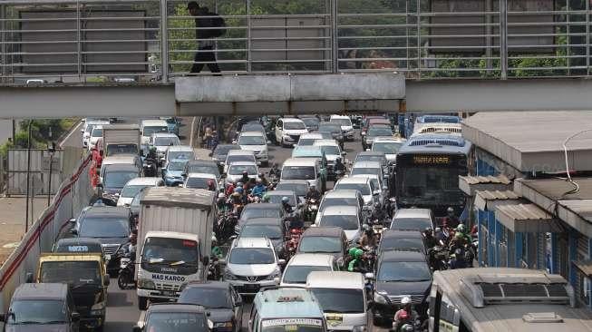 Suasana macet dan tumpukan kendaraan di sepanjang jalan tol dalam kota MT Haryono, Cawang, Jakarta, Senin (7/8/2017), di mana sementara itu BPS mencatat adanya penurunan daya beli otomotif pada semester I-2017. [Suara.com/Kurniawan Mas'ud]