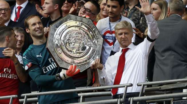 Manajer Arsenal Arsene Wenger (kanan) dan kiper Petr Cech (L) mengangkat trofi Community Shield. Ian KINGTON / AFP