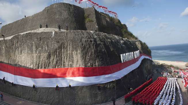 Pengibaran Bendera Merah Putih di Pantai Pandawa, Badung, Bali, Senin (14/8).