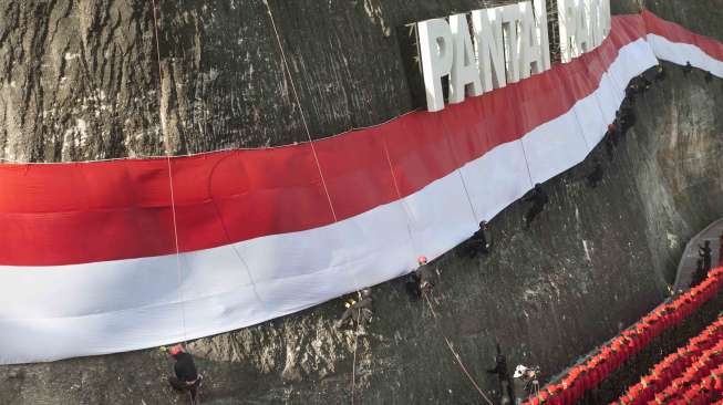 Pengibaran Bendera Merah Putih di Pantai Pandawa, Badung, Bali, Senin (14/8).