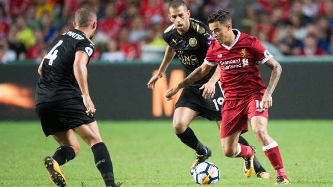 Pemain Liverpool Philippe Coutinho mencoba melewati dua pemain Leicester City dalam laga pramusim [AFP]