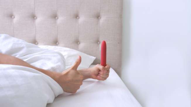 Ilustrasi perempuan memegang dildo (Shutterstock)