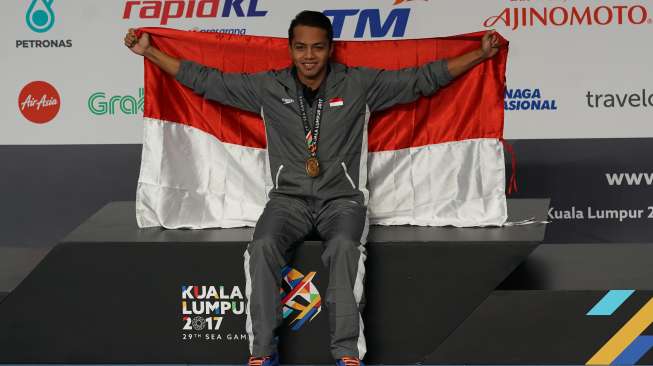 Perenang Indonesia, I Gede Siman Sudartawa, merentangkan bendera Merah Putih usai menjuarai final renang 50 meter gaya punggung putra SEA Games XXIX di National Aquatic Centre, Kuala Lumpur, Malaysia, Senin (21/8/2017) malam. [Antara/Sigid Kurniawan]