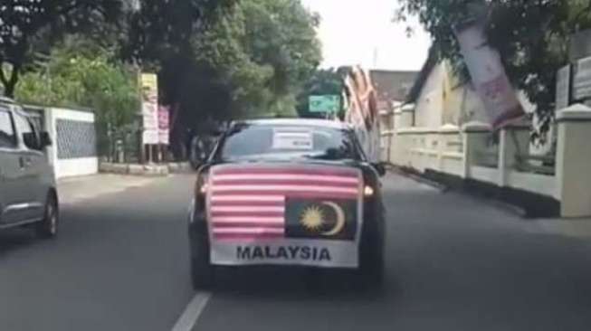 Bambang Saptono arak bendera Malaysia dalam posisi terbalik. [Instagram]