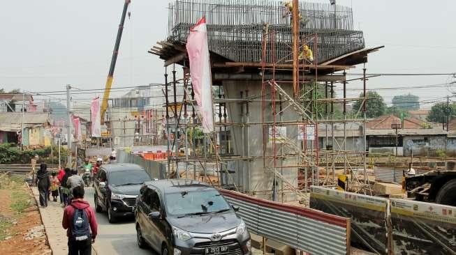 Sejumlah kendaraan melintas di samping proyek pembangunan jalan layang (flyover) Bintaro, Jakarta, Kamis (24/8).