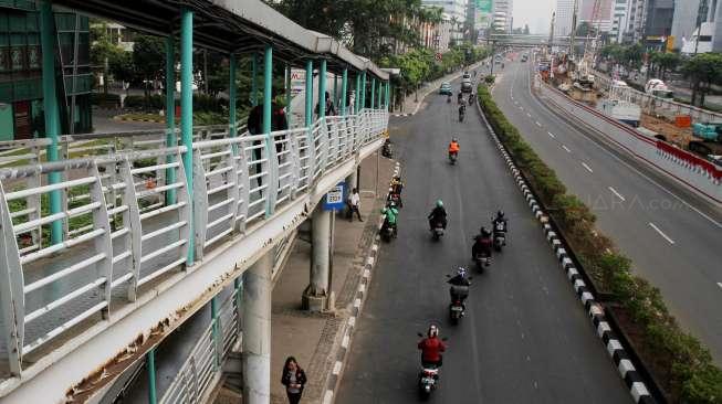 Pengendara sepeda motor melintas di Jalan HR Rasuna Said, Kuningan, Jakarta, Sabtu (26/8).