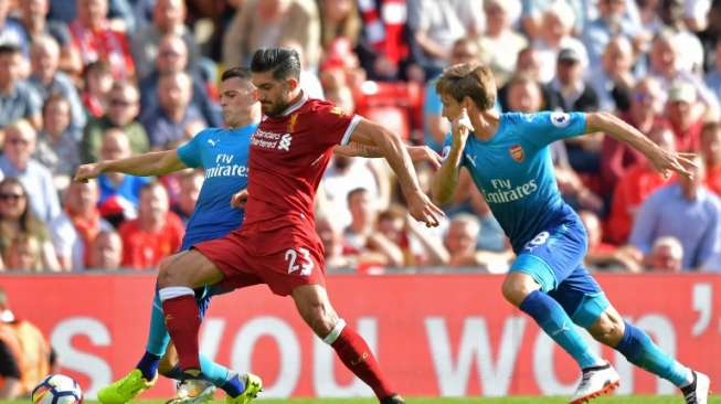 Dua pemain Arsenal mencoba menghentikan laju gelandang Liverpool, Emre Can [AFP]