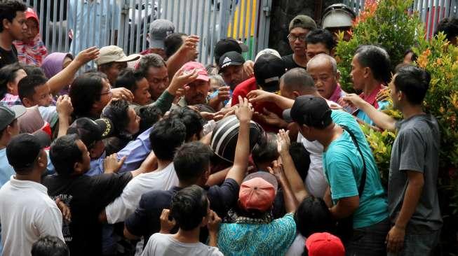 Warga mengantre pembagian hewan kurban di kantor DPP Lembaga Dakwah Islam Indonesia (LDII), Jakarta, Jumat (1/9).