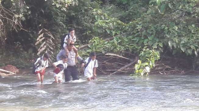 Heroik, Aipda Ismet Setiap Hari Bantu Siswa SD Lawan Arus Sungai