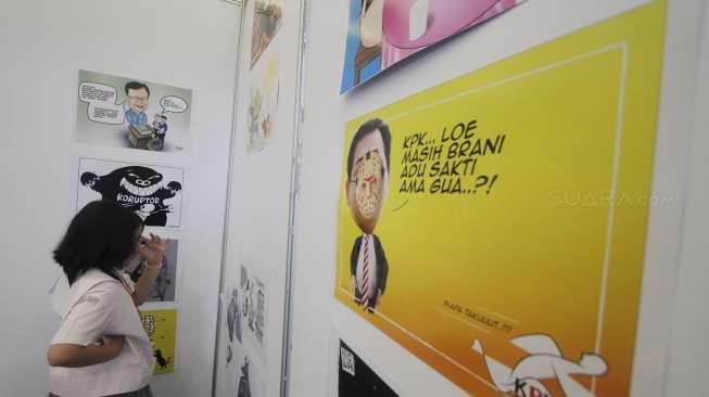 Pengunjung melihat-lihat gambar dan informasi yang dipajang di stan KPK pada pameran Indonesia International Book Fair (IIBF) 2017 di Jakarta Convention Center (JCC), Sabtu (9/9/2017). [Suara.com/Oke Atmaja]