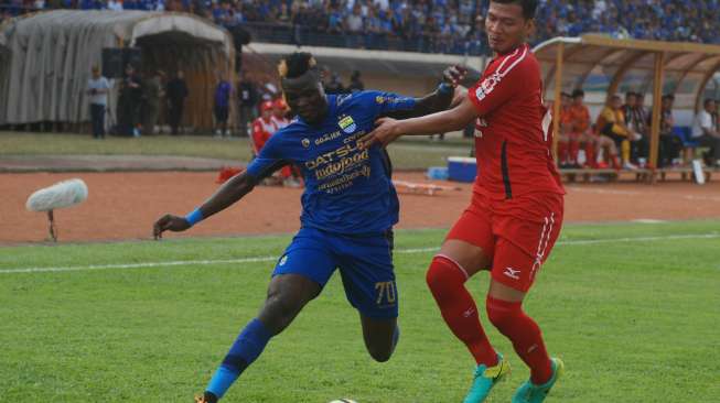 Pemain Persib Bandung Ezechiel Ndouasel (kiri) berebut bola dengan pemain Semen Padang FC Agung Prasetyo (kanan) di Stadion Si Jalak Harupat Soreang. ANTARA FOTO/Fahrul Jayadiputra