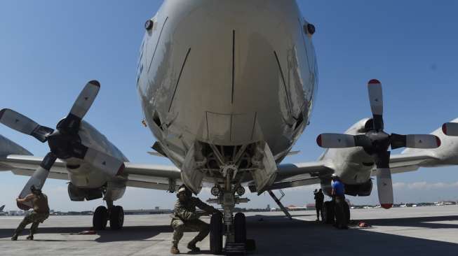 Prajurit US Navy memeriksa kondisi pesawat P-3C Orion usai latihan patroli bersama TNI AL di atas perairan Laut Jawa di Base Ops Puspenerbal, Juanda Sidoarjo, Jawa Timur, Sabtu (9/9/2017). [Antara/Zabur Karuru]
