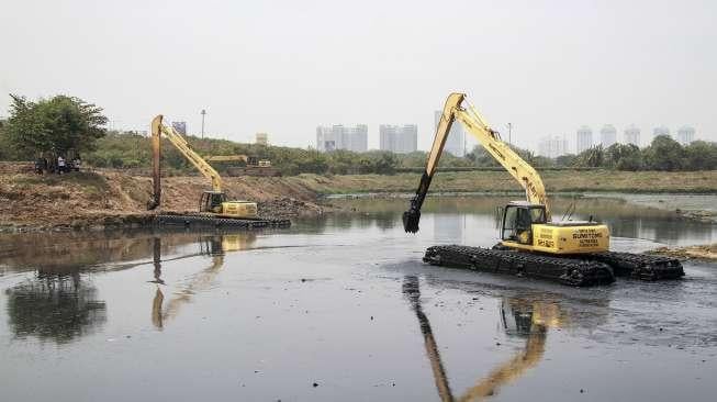 Petugas Dinas Sumber Daya Air Provinsi DKI Jakarta Bidang Aliran Timur mengeruk endapan lumpur di Waduk Ria Rio, Pulogadung, Jakarta, Kamis (14/9).