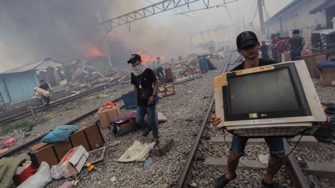 Warga berusaha menyelamatkan harta bendanya dari lokasi kebakaran di Kampung Bandan, Jakarta, Sabtu (16/9).