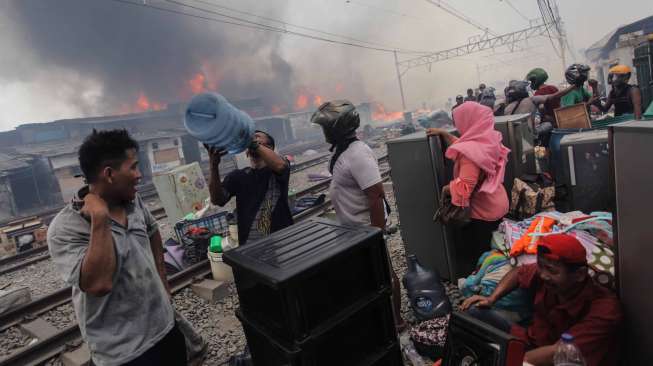 Warga berusaha menyelamatkan harta bendanya dari lokasi kebakaran di Kampung Bandan, Jakarta, Sabtu (16/9).