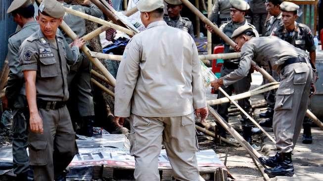 Sejumlah petugas Satpol PP terlihat melakukan penertiban pedagang kaki lima (PKL) di sepanjang trotoar kawasan Stasiun Manggarai, Jakarta, Senin (18/9/2017). [Suara.com/Oke Atmaja]