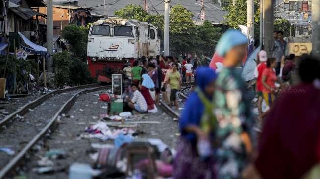 Aktivitas sejumlah warga korban kebakaran yang masih bertahan di tenda-tenda pengungsian di sisi rel kereta api kawasan Kampung Bandan, Jakarta, Senin (18/9/2017). [Suara.com/Kurniawan Mas'ud]