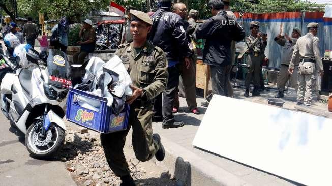 Sejumlah petugas Satpol PP saat melakukan penertiban pedagang kaki lima (PKL) di sepanjang trotoar kawasan Stasiun Manggarai, Jakarta, Senin (18/9/2017). [Suara.com/Oke Atmaja]