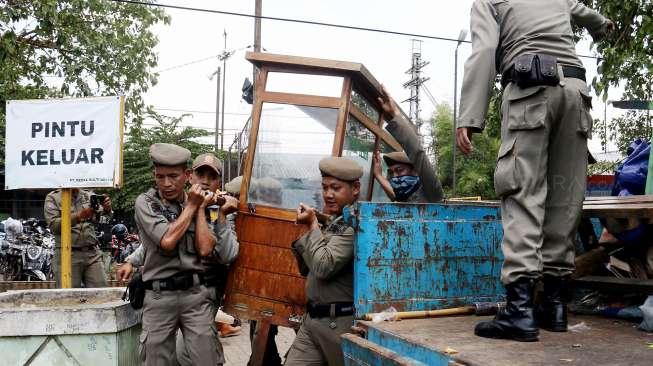 Petugas Satpol PP saat melakukan penertiban pedagang kaki lima (PKL) di sepanjang trotoar kawasan Stasiun Manggarai, Jakarta, Senin (18/9/2017). [Suara.com/Oke Atmaja]