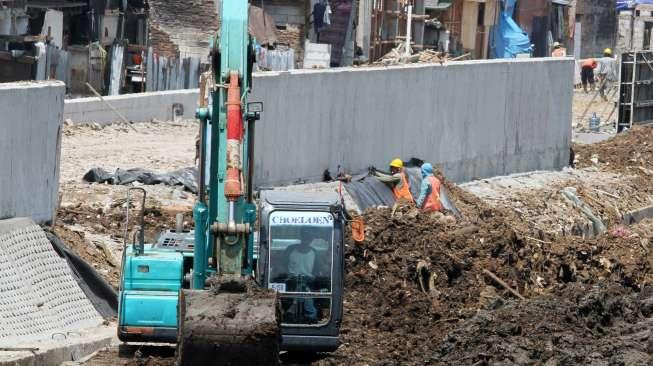 Pekerja menyelesaikan proyek normalisasi kali Ciliwung di kawasan Bukit Duri, Jakarta, Selasa (19/9).