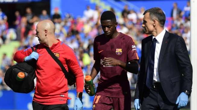 Pemain Barcelona Ousmane Dembele (tengah) berjalan keluar lapangan dengan tim dokter setelah mengalami cedera saat menghadapi Getafe. PIERRE-PHILIPPE MARCOU / AFP