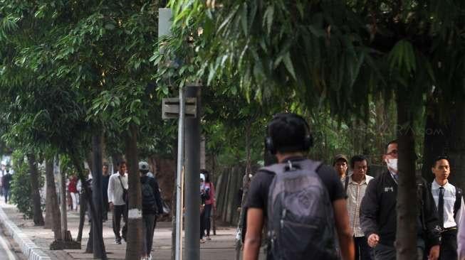 Sejumlah pejalan kaki terlihat melintas di kawasan Jalan Sudirman, Jakarta, Rabu (20/9/2017). [Suara.com/Oke Atmaja]