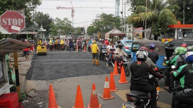 Petugas Sudin Binamarga Jakarta Pusat melakukan perbaikan jalan di perlintasan kereta api di Manggarai, Jakarta, Senin (25/9).