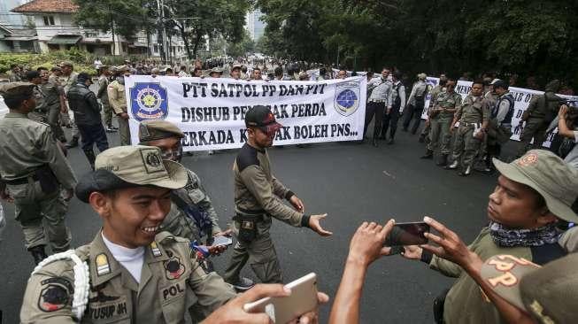 Ratusan personel Satpol PP dan Dishub DKI Jakarta menggelar unjuk rasa di depan kantor Kementerian Pendayagunaan Aparatur Negara dan Reformasi Birokrasi (KemenPAN-RB) di Jakarta, Senin (25/9).