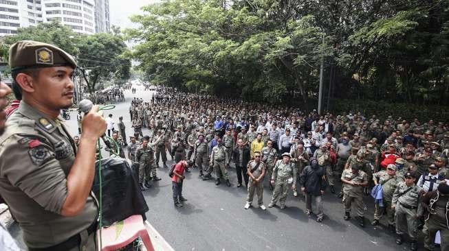 Ratusan personel Satpol PP dan Dishub DKI Jakarta menggelar unjuk rasa di depan kantor Kementerian Pendayagunaan Aparatur Negara dan Reformasi Birokrasi (KemenPAN-RB) di Jakarta, Senin (25/9).