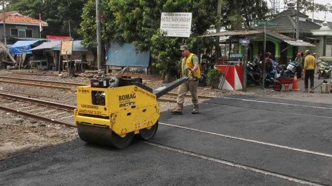 Petugas Sudin Binamarga Jakarta Pusat melakukan perbaikan jalan di perlintasan kereta api di Manggarai, Jakarta, Senin (25/9).