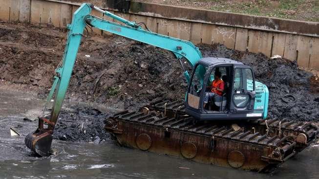 Petugas melakukan pengerukan lumpur dengan alat berat di Kali Ciliwung, Karet, Jakarta, Jumat (29/9).